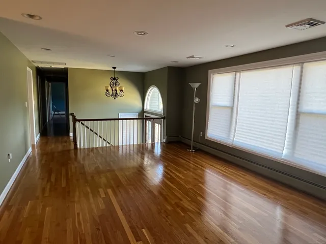 a view of a livingroom with wooden floor and a ceiling fan