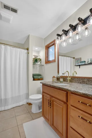 a bathroom with a granite countertop sink a toilet and a mirror