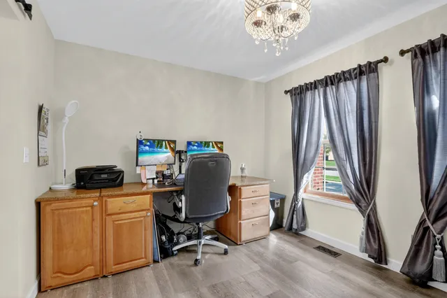 a view of a workspace with furniture and a window