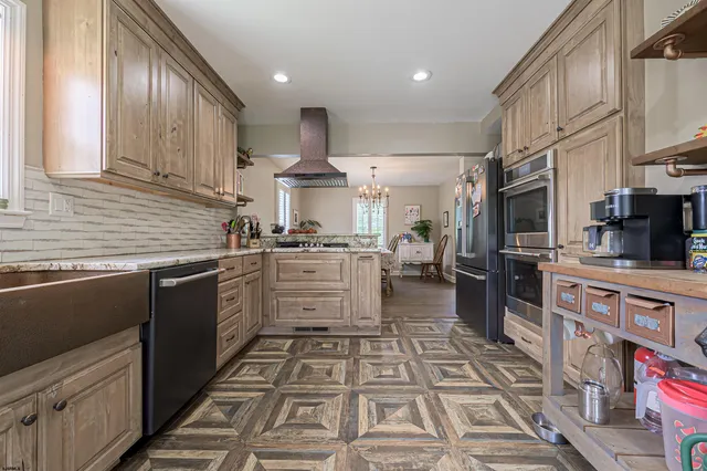 a kitchen with stainless steel appliances granite countertop a stove a sink and a refrigerator