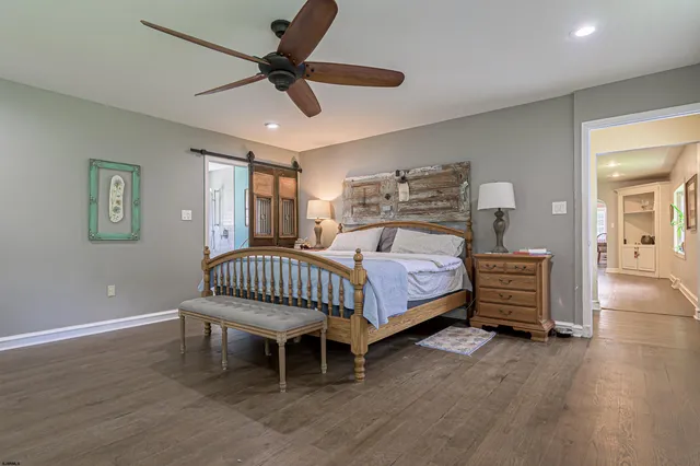 a bedroom with a bed chairs and a window