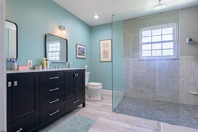 a bathroom with a double vanity sink toilet and a mirror