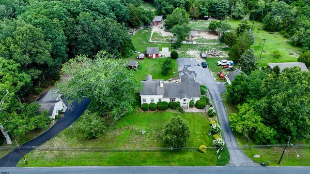 an aerial view of residential houses with outdoor space and trees all around