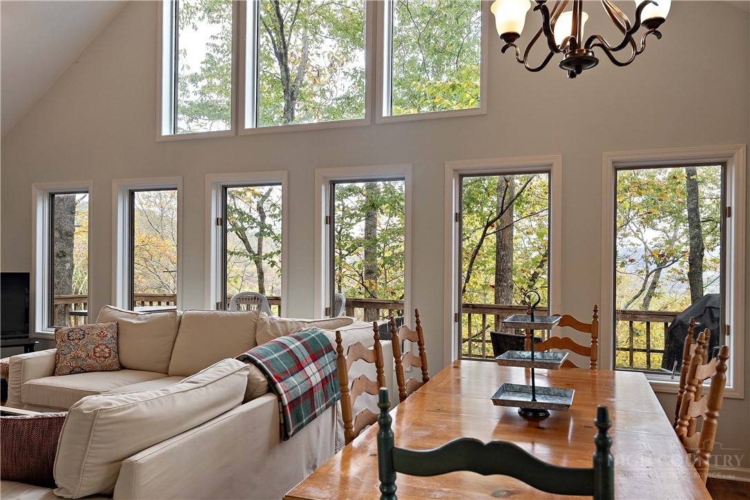 a living room with furniture large windows and wooden floor