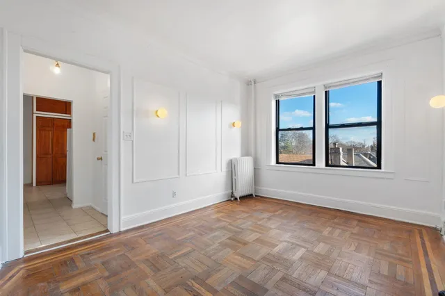 a view of an empty room with window and bathroom
