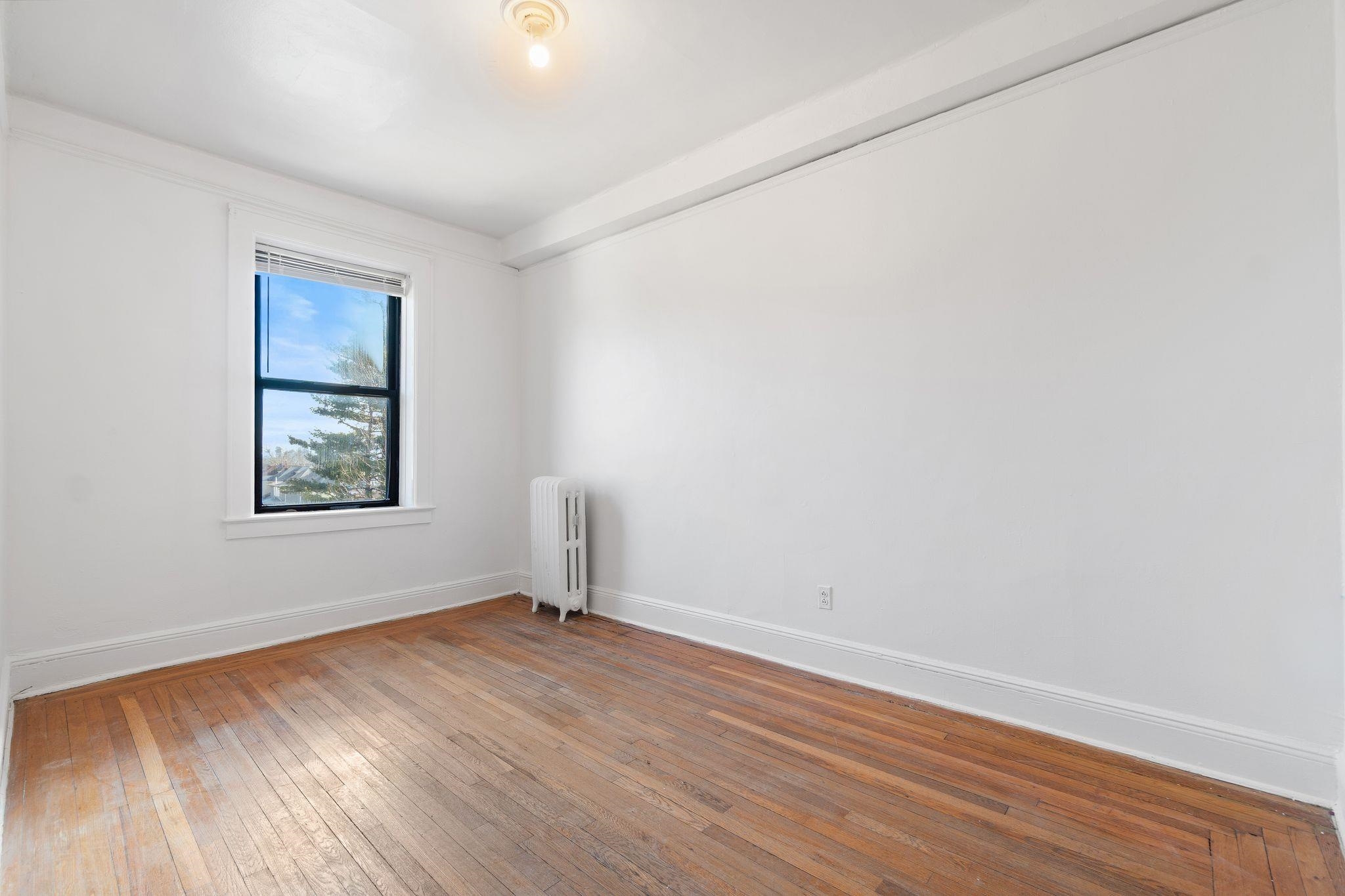 435 79th Street, Unit 47 North Bergen, NJ 07047 - Photo 6 of 20 an empty room with wooden floor and windows