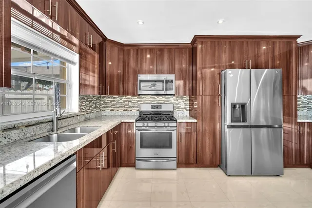 a kitchen with stainless steel appliances granite countertop a refrigerator stove and sink