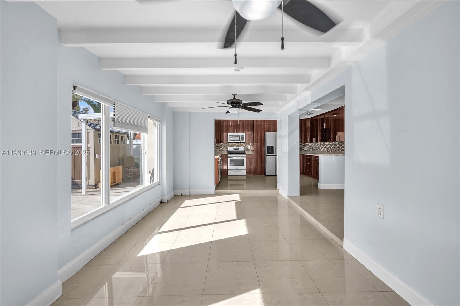 8300 Northwest 201st Street Hialeah, FL 33015 - Photo 14 of 33 a view of a hallway with a window and a kitchen