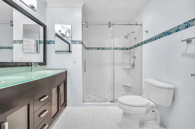 a bathroom with a granite countertop sink a toilet and shower