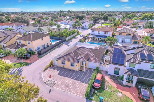 an aerial view of residential houses with outdoor space and parking