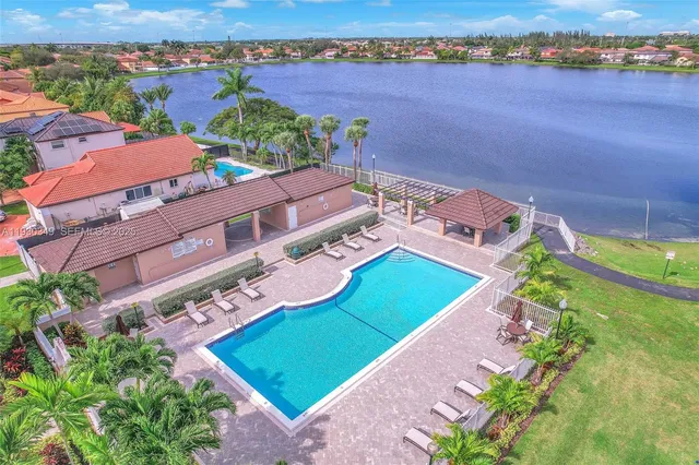 an aerial view of a house with a garden and lake view