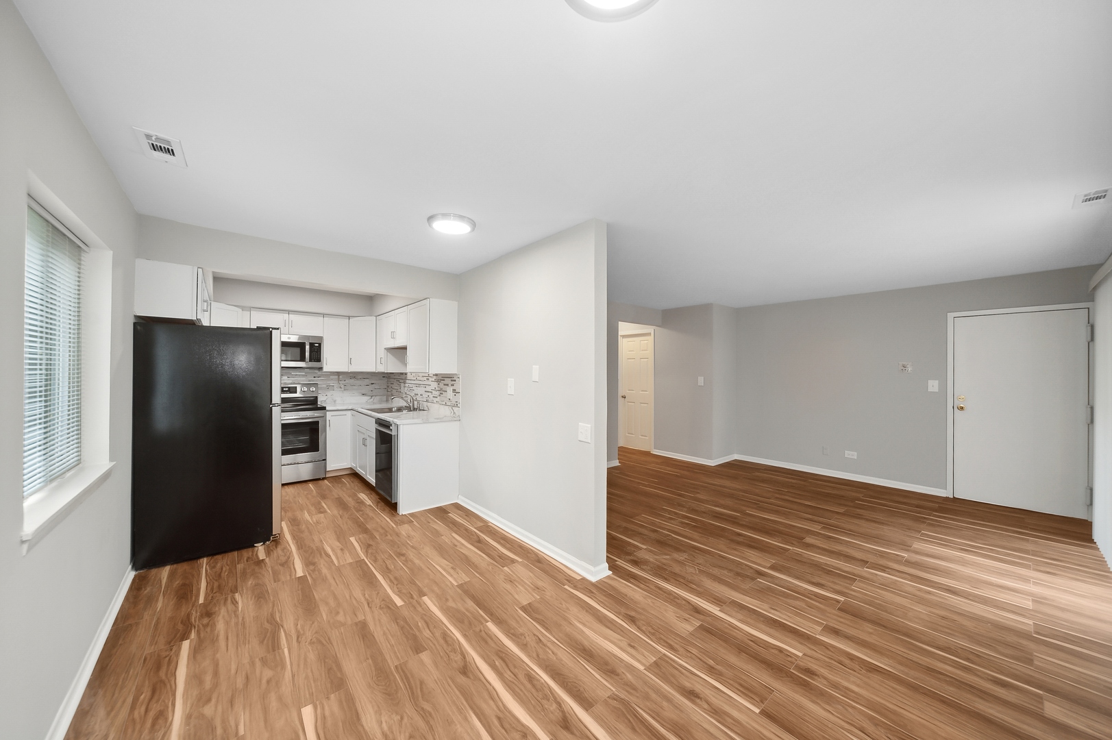 1779 West Algonquin Road, Unit 1A Mount Prospect, IL 60056 - Photo 5 of 15 a kitchen with wooden floors and refrigerator