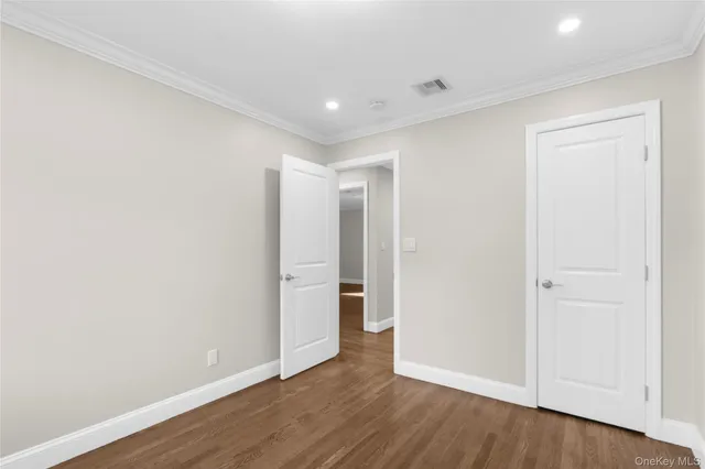 an empty room with wooden floor and window