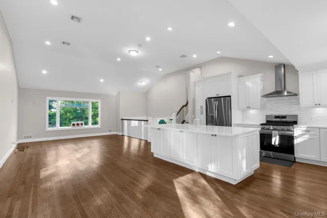 a kitchen with hard wood floors and white cabinets