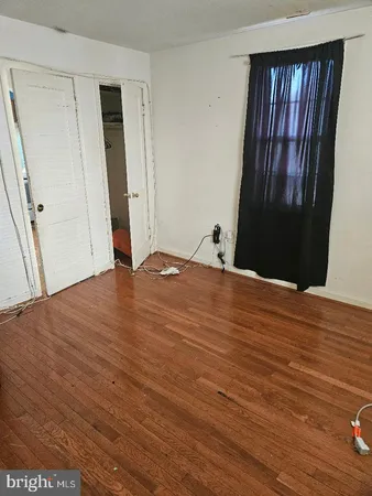 an empty room with wooden floor and window