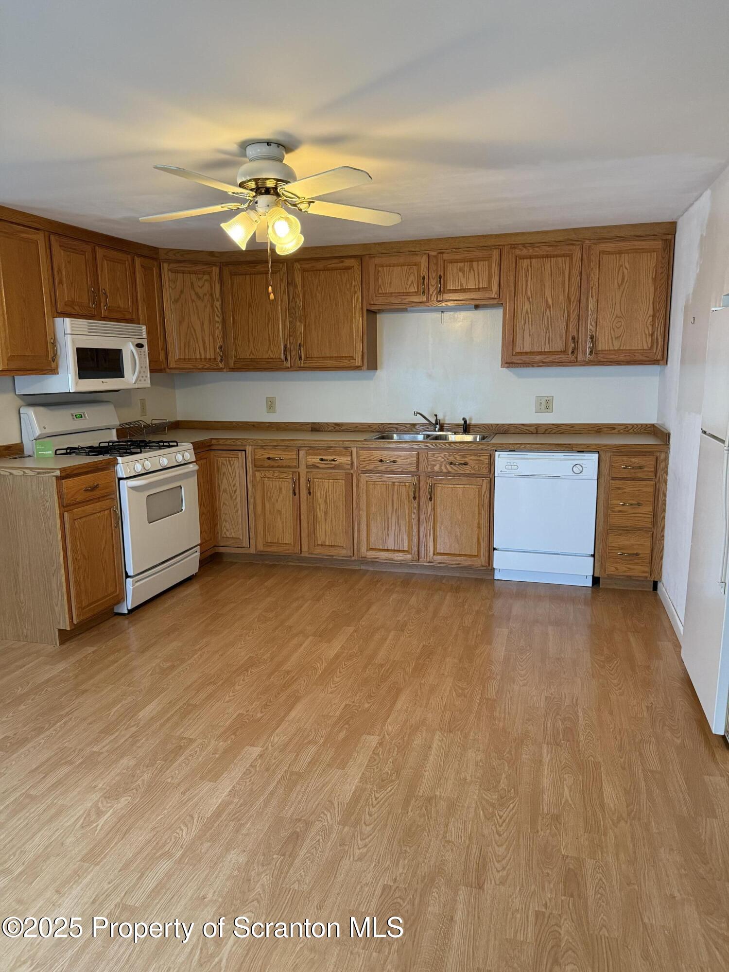 3886 Bow Bridge Road Friendsville, PA 18818 - Photo 25 of 71 a kitchen with granite countertop a stove top oven a sink dishwasher and a fireplace with wooden floor