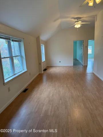 a view of a hallway with furniture and wooden floor