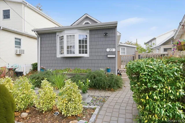 a view of a brick house with a flower garden