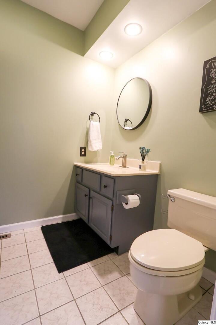 2123 South 30th Street Quincy, IL 62301 - Photo 26 of 36 a bathroom with a toilet a sink and mirror