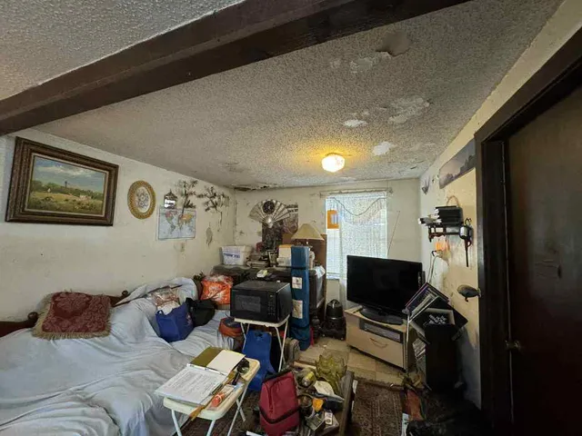 a bedroom with furniture and a flat screen tv