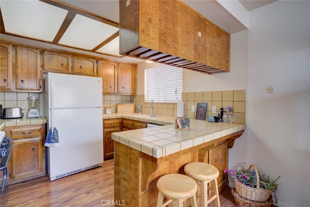 1165 Maple Street, Unit E Arroyo Grande, CA 93420 - Photo 15 of 50 a kitchen with a refrigerator a stove and a table