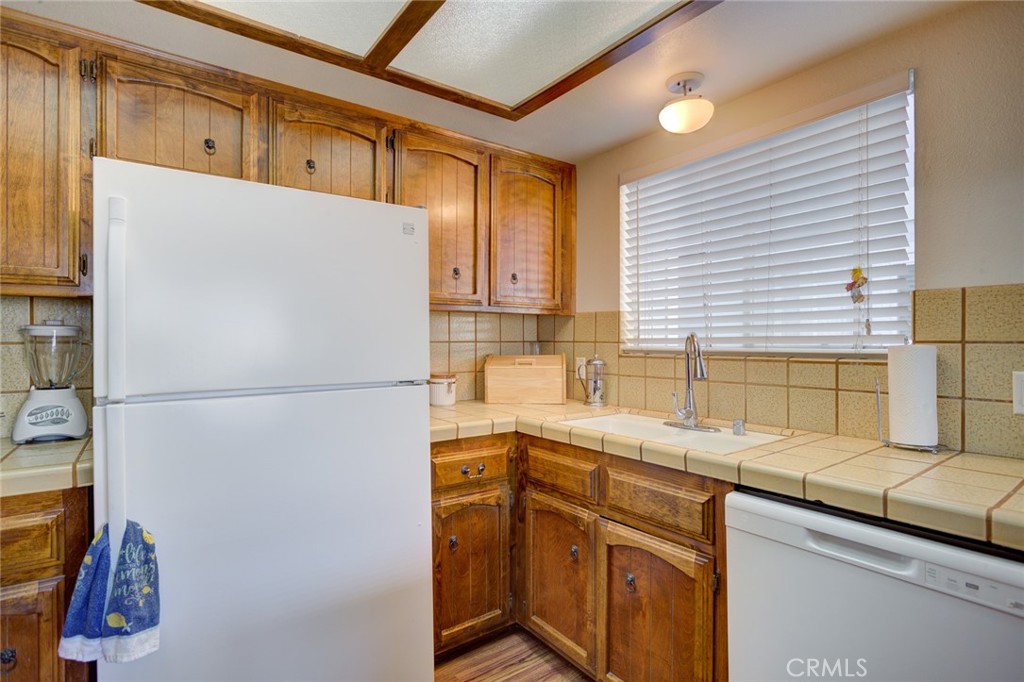 1165 Maple Street, Unit E Arroyo Grande, CA 93420 - Photo 17 of 50 a kitchen with stainless steel appliances granite countertop a refrigerator a sink and white cabinets