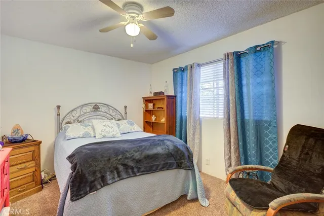 a bedroom with a bed and a flat tv screen on dresser