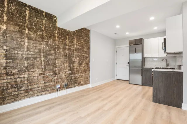 a view of kitchen with granite countertop cabinets and refrigerator