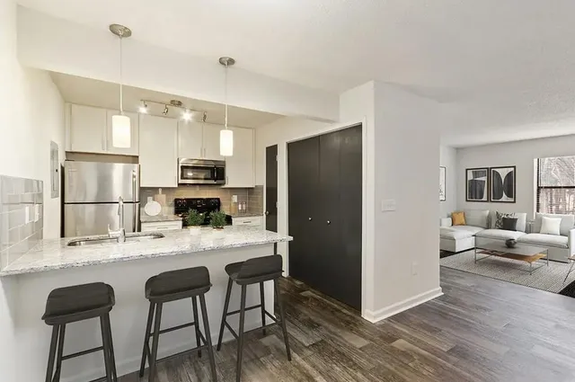 a kitchen with stainless steel appliances kitchen island granite countertop a refrigerator and a stove top oven