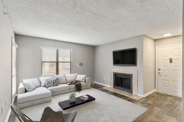 a living room with furniture a flat screen tv and a fireplace