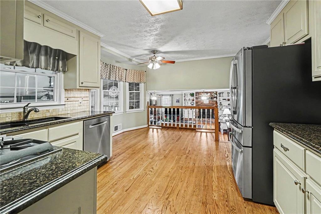 740 Smyrna Road Southwest Conyers, GA 30094 - Photo 8 of 27 a kitchen with stainless steel appliances granite countertop a refrigerator a stove and a wooden floors