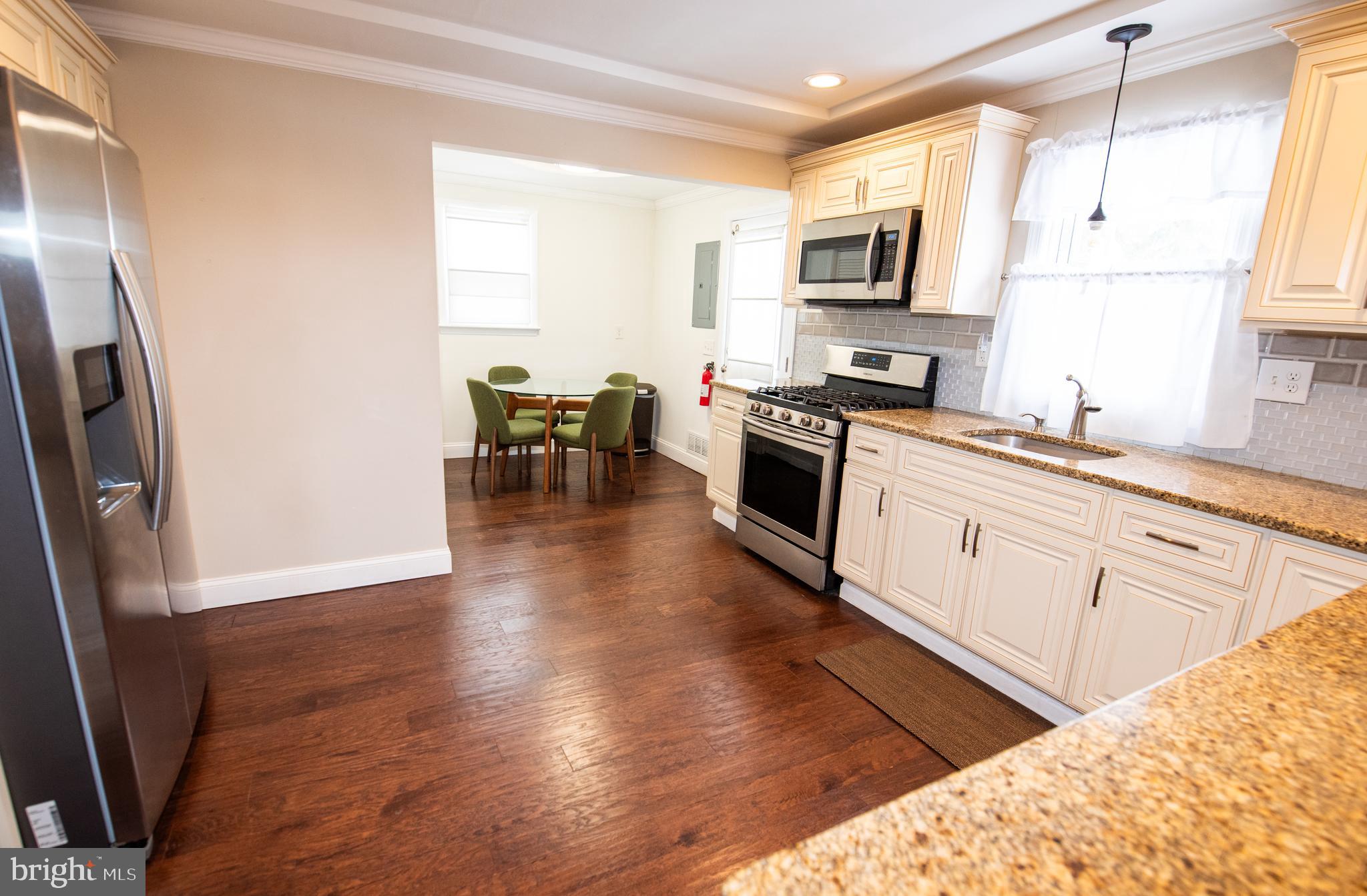 452 Elm Avenue Maple Shade, NJ 08052 - Photo 9 of 31 a kitchen with granite countertop a stove top oven a sink a dining table and chairs