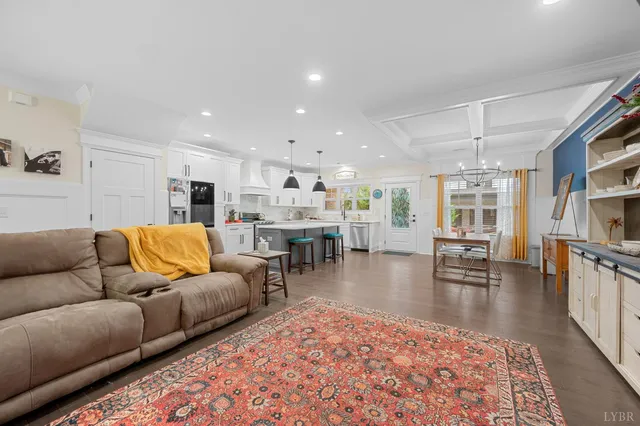 a kitchen with stainless steel appliances granite countertop a refrigerator a sink dishwasher a stove and white cabinets with wooden floor