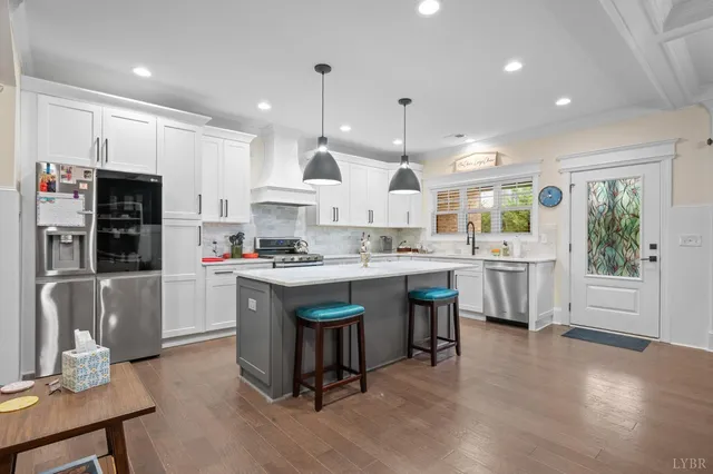 a kitchen with stainless steel appliances granite countertop a sink a stove and cabinets