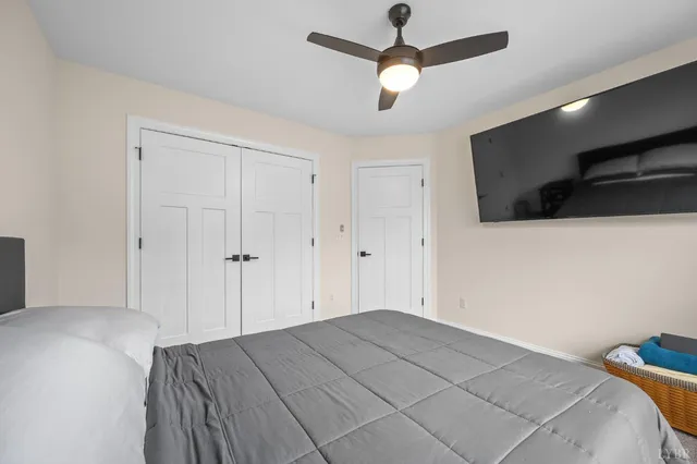 a bedroom with a bed a flat screen tv and a large window