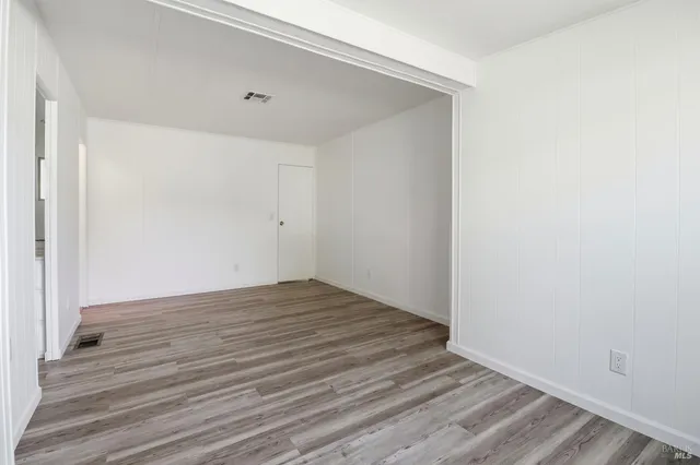 a view of an empty room with wooden floor