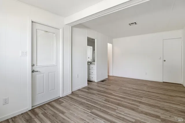 a view of an empty room with wooden floor