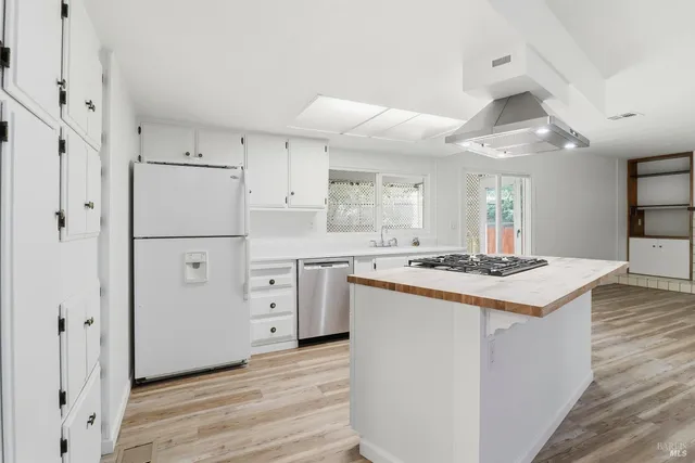 a kitchen with white cabinets and white appliances