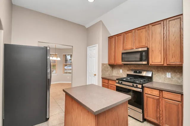 a kitchen with stainless steel appliances granite countertop a stove top oven a sink dishwasher and a microwave oven on the blue kitchen countertops