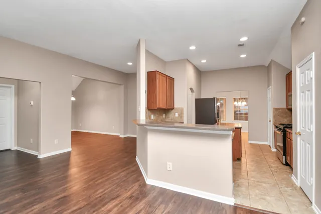 a view of a kitchen with kitchen island a sink stainless steel appliances and cabinets