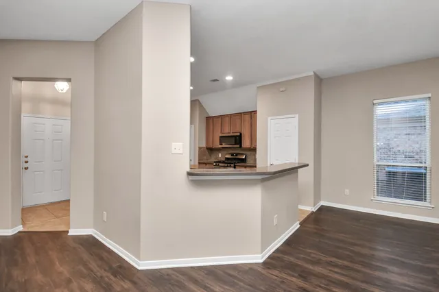 a kitchen with stainless steel appliances a sink and wooden floor