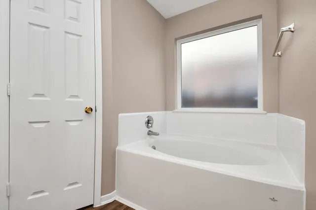 a white bath tub sitting next to a shower