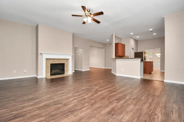 a view of a kitchen with a ceiling fan hardwood floor and a kitchen