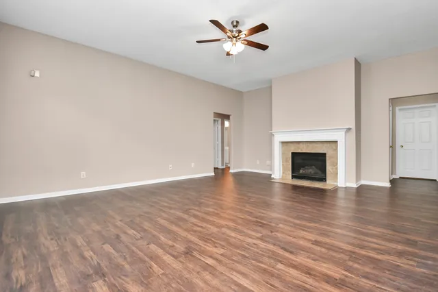 a view of empty room with wooden floor and fireplace