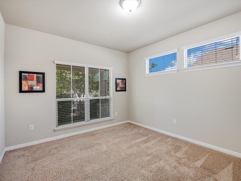 141 Serrano Street Georgetown, TX 78628 - Photo 8 of 19 Well-lit room with generous window placement and comfortable carpeting.