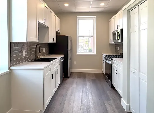 a kitchen with stainless steel appliances granite countertop a stove a sink and a refrigerator