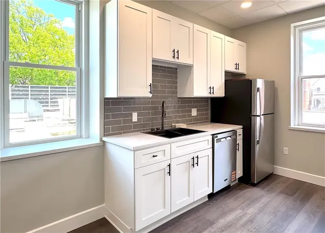 a kitchen with stainless steel appliances a refrigerator sink and cabinets