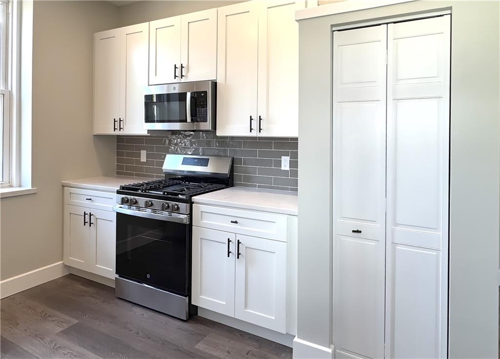 422 Walnut Street, Unit 1 Sewickley, PA 15143 - Photo 7 of 13 a kitchen with stainless steel appliances a stove a microwave and a window