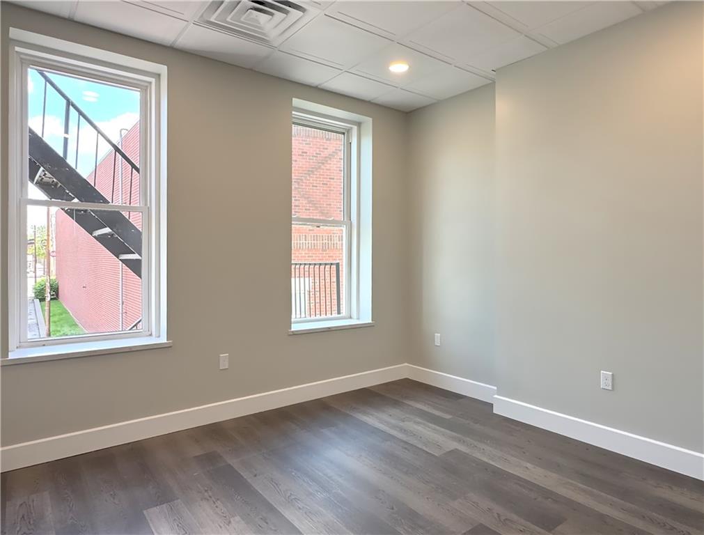 422 Walnut Street, Unit 1 Sewickley, PA 15143 - Photo 8 of 13 an empty room with wooden floor and windows
