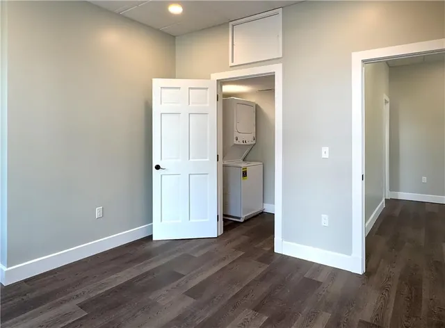 an empty room with wooden floor and entrance